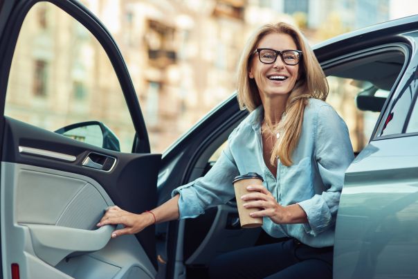 A person opening the door of their leased business car.